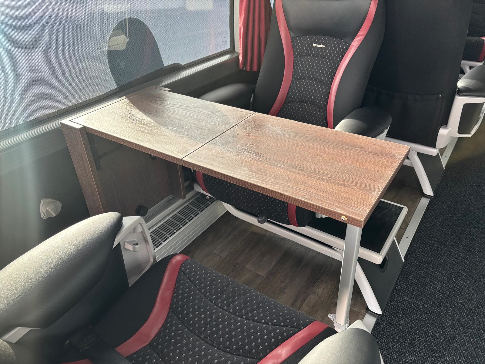 Table de travail en bois dépliée entre deux sièges de l'autocar